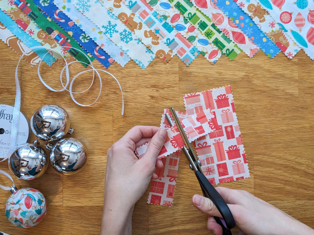 Point of view photograph of cutting scraps of fabric into 1 inch squares